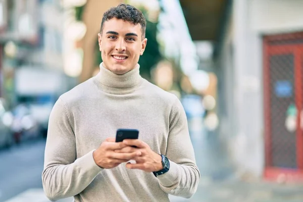 若いヒスパニック系の男は 市内でスマートフォンを使用して幸せな笑顔 — ストック写真