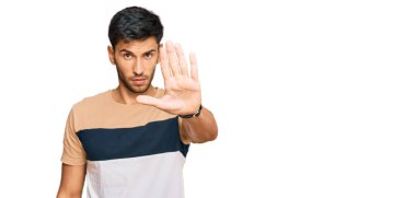 Sıradan kıyafetler giyen genç yakışıklı bir adam avucunun içi gibi şarkı söylemeyi kesiyor. Yüzünde olumsuz ve ciddi bir jest olan uyarı ifadesi. 