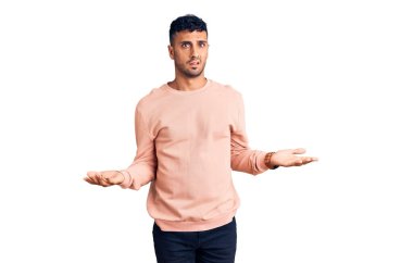 Gündelik giysiler giyen genç İspanyol adam habersiz ve kolları açık, hiçbir fikri yok.. 