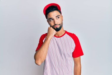 Beyzbol üniforması giyen sakallı genç adam şüphe üzerine yoğunlaşmıştı. Parmakları çenesinde ve yukarı bakıyordu. 