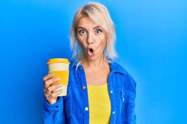Sarışın genç kız kahveyi alıp götürüyor. Korkmuş ve şaşkın bir şekilde ağzı açık, şaşırmış, inançsız bir yüz. 