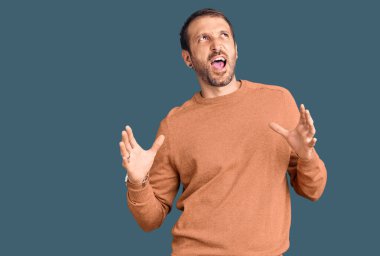 Genç, yakışıklı, sıradan kıyafetler giyen çılgın ve deli gibi bağıran agresif bir ifade ve kollarla bağıran bir adam. hüsran kavramı. 