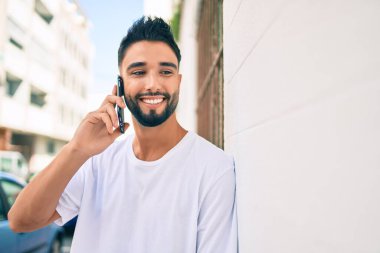 Şehirdeki akıllı telefondan konuşan, ciddi bir suratı olan genç bir Arap..