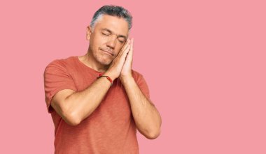 Yakışıklı, orta yaşlı, rahat kıyafetler giyen, yorgun uyuyan, hayal kuran, elleriyle poz veren ve gözleri kapalı gülümseyen bir adam.. 