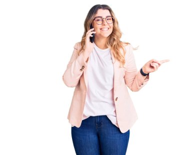 Beyaz bir kadın akıllı telefondan konuşuyor. Gülümsüyor, mutlu bir şekilde elini ve parmağını yana uzatıyordu. 