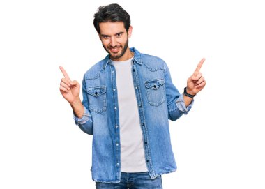 Gündelik kıyafetler giyen, kendine güvenen, parmaklarını farklı yönlere çeviren genç İspanyol adam. reklam için kopyalama alanı 