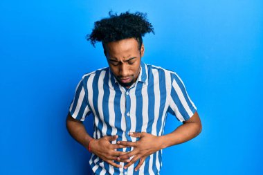 Sakallı, sıradan çizgili tişörtlü, midesi üstünde genç Afro-Amerikalı bir adam. Çünkü hazımsızlık, acı verici bir hastalık ve kendini iyi hissetmiyor. Ağrı kavramı. 