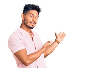 Yakışıklı Latin Amerikalı rahat bir yaz gömleği giyen genç adam gülümseyerek içeri girmeye davet ediyor. 