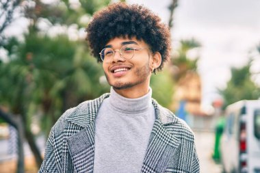 Genç Afrikalı Amerikalı işadamı parkta mutlu bir şekilde dikiliyor.