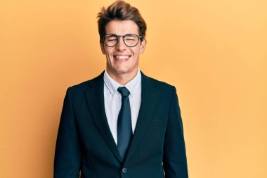 Yakışıklı, beyaz takım elbiseli, kravatlı, yüzünde mutlu ve havalı bir gülümseme olan bir adam. şanslı kişi. 