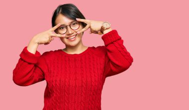 Kısa saçlı, kısa saçlı, gözlüklü, barış sembolü takan, yüzünde gülümsemeyle zafer gösteren genç ve güzel bir İspanyol kadın. 