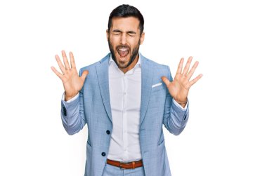 İş ceketi giyen genç İspanyol adam başarı için deli ve çılgınlığı kutluyor kollarını kaldırmış ve gözlerini kapatmış heyecanla bağırıyor. Kazanan konsept 