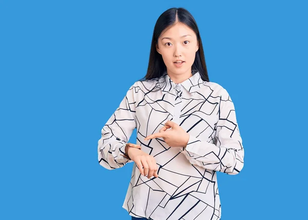 若い美しい中国人女性身に着けているカジュアルシャツで急いで時間を見るために指す 動揺し 締め切り遅延のために怒っている — ストック写真