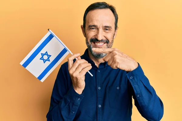 Medelåldern Hispanic Man Håller Israel Flagga Ler Glad Pekar Med — Stockfoto