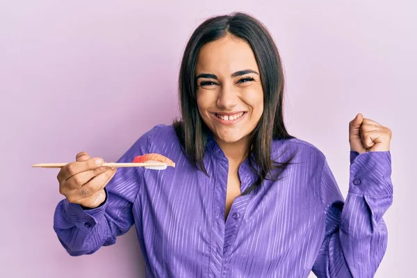 Joven Morena Comiendo Sushi Usando Palillos Gritando Orgullosa Celebrando Victoria —  Fotos de Stock