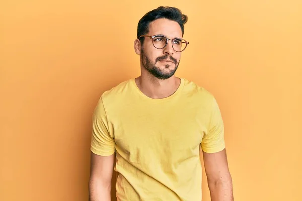 Junger Hispanischer Mann Lässiger Kleidung Und Brille Lächelt Zur Seite — Stockfoto