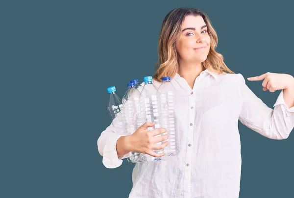 Jonge Blanke Vrouw Houden Recycling Plastic Flessen Wijzend Vinger Naar — Stockfoto