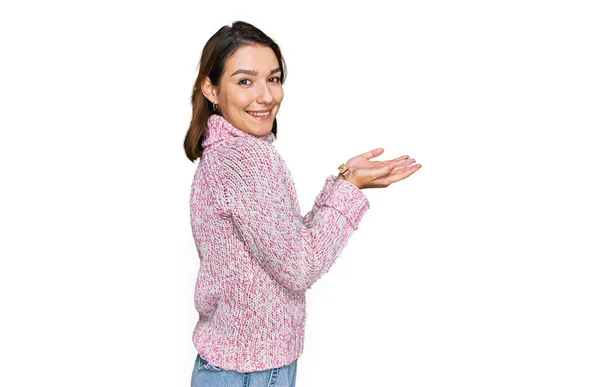 年轻的高加索女孩穿着羊毛冬季毛衣 手拉手 张开手掌 展示复制的空间 呈现广告笑容满面 喜形于色 — 图库照片