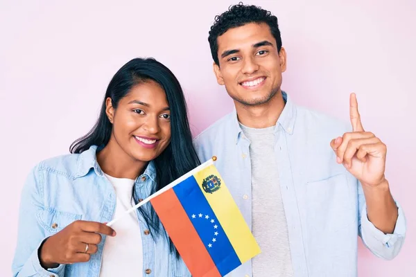 Красивая Латинская Молодая Пара Венезуэльским Флагом Улыбающаяся Идеей Вопросом Указывающая — стоковое фото