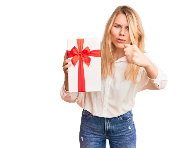 Young Beautiful Blonde Woman Holding Gift Pointing Finger Camera You — Stock Photo, Image