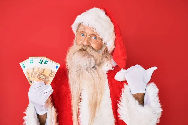 Old Senior Man Wearing Santa Claus Costume Holding Euros Pointing — Stock Photo, Image