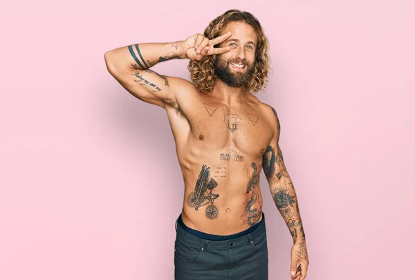 Przystojny Mężczyzna Brodą Długimi Włosami Stojący Bez Koszuli Tatuażami Robiącymi — Zdjęcie stockowe