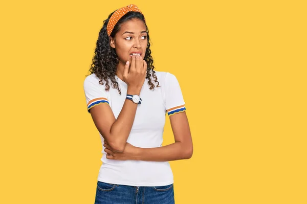 穿着休闲装的年轻的非洲裔美国女孩看上去很紧张 双手放在咬指甲的嘴上 焦虑问题 — 图库照片