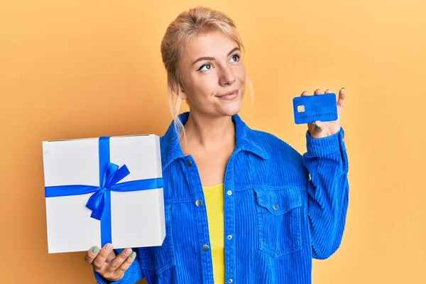 Junges Blondes Mädchen Mit Geschenk Und Kreditkarte Lächelt Zur Seite — Stockfoto