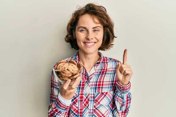 Çikolata Parçalı Kurabiyeler Taşıyan Genç Esmer Kadın Bir Fikirle Gülümsüyor — Stok fotoğraf