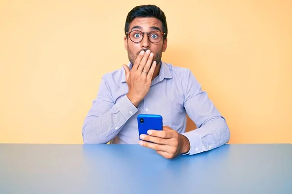 Junge Hispanische Mann Mit Smartphone Auf Dem Tisch Sitzend Mund — Stockfoto