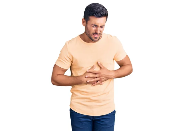 若いヒスパニック系の男性胃の上に手でカジュアルな服を着ているため 消化不良 痛みを伴う病気の気分が悪い キャッシュ コンセプト — ストック写真