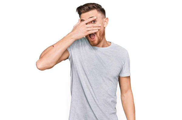 Νεαρός Κοκκινομάλλης Άνδρας Φορώντας Casual Γκρι Shirt Κρυφοκοιτώντας Στο Πρόσωπο — Φωτογραφία Αρχείου