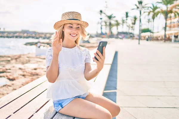 若いですCaucasian Tourist Girl堂でベンチに座ってスマートフォンを使用してビデオ通話を行う — ストック写真