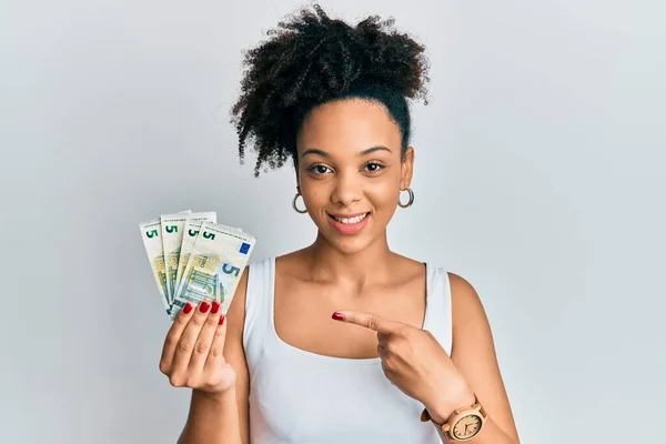 Νεαρή Αφροαμερικανίδα Που Κρατά Χαρτονομίσματα Των Ευρώ Χαμογελώντας Χαρούμενη Δείχνοντας — Φωτογραφία Αρχείου