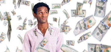 Sıradan pembe gömlek giyen Afrikalı yakışıklı adam gülümseyip yan tarafa bakıyor ve düşünüyor..