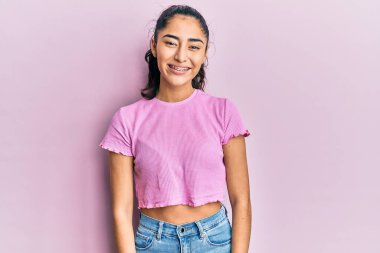 Diş teli takan, sıradan kıyafetler giyen, mutlu ve havalı bir gülümsemesi olan İspanyol bir genç kız. şanslı kişi. 