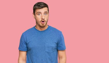 Yakışıklı, günlük kıyafetler giyen, korku ve heyecan dolu bir yüz ifadesinden korkan ve şok olan beyaz bir adam.. 