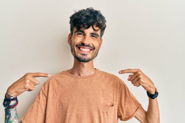 Günlük kıyafetler giyen, kendine güveni olan, kendini gururlu ve mutlu gösteren genç İspanyol bir adam.. 