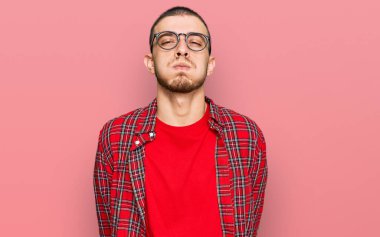 Günlük kıyafetler giyen İspanyol genç adam komik yüzlü yanakları şişiriyor. Havayla şişmiş ağız, çılgın bir ifade.. 