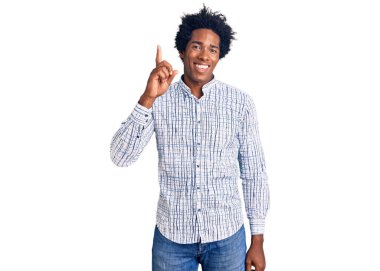 Afro saçlı, sıradan giyinmiş, başarılı bir fikri işaret eden yakışıklı Afro-Amerikalı adam. Heyecanlı ve mutlu. Bir numara.. 
