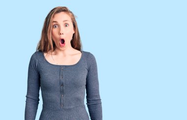 Genç, güzel, sarışın bir kadın gündelik kıyafetler giyiyor. Şaşırmış ve korkmuş bir ifade, korku ve heyecanlı bir yüz ifadesi var.. 