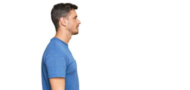 Yakışıklı, günlük kıyafetler giyen, rahat bir görünüm takınan, kendine güvenen bir gülümsemesi olan beyaz bir adam.. 