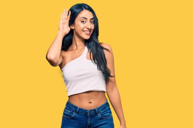 Gündelik kıyafetler giyen, ağzı kulaklarında gülümseyen, dedikoduları ve dedikoduları dinleyen güzel İspanyol bir kadın. Sağırlık kavramı. 