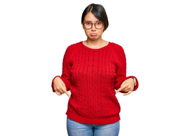 Kısa saçlı, gözlüklü, üzgün ve üzgün görünen üzgün ve yönünü parmaklarıyla belirten kısa boylu İspanyol bir kadın.. 