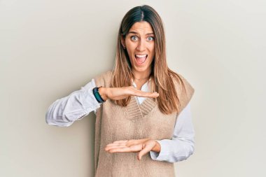 Esmer genç bir kadın, elinde görünmez bir nesne tutarak çılgın ve başarıyı kutluyor. Gözleri açık, heyecanlı bir şekilde haykırıyor.. 