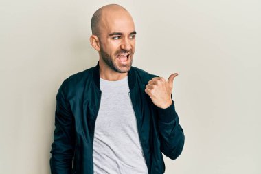 Sıradan spor ceket giyen genç İspanyol adam baş parmağını yukarı kaldırıyor ve ağzı açık gülümsüyor. 