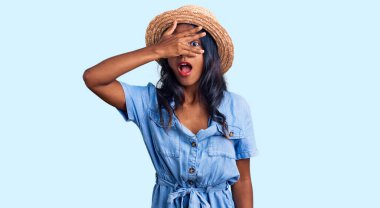 Genç Hintli kız yaz şapkası takıyor. Şoka giriyor. Yüzünü ve gözlerini kapatıyor.. 