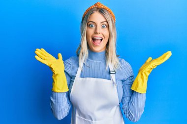Güzel sarışın kadın temiz önlük ve eldiven giyerek çılgınlığı kutluyor ve başarıyı kolları açık ve gözleri açık heyecanla haykırarak kutluyor. Kazanan konsept 