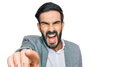 İş kıyafetleri giymiş genç İspanyol bir adam kameraya kızgın ve sinirli bir şekilde seni işaret ediyor. 