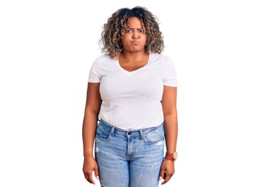 Young african american plus size woman wearing casual clothes puffing cheeks with funny face. mouth inflated with air, crazy expression.  clipart